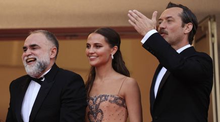 British actor Jude Law (R) waves as he arrives with Swedish actress Alicia Vikander (C) and Brazilian film director Karim Ainouz for the screening of the film "Firebrand" during the 76th edition of the Cannes Film Festival in Cannes, southern France, on May 21, 2023. (Photo by Valery HACHE / AFP) © Valery HACHE / AFP